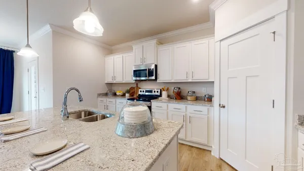 a kitchen with granite countertop a sink a stove and cabinets