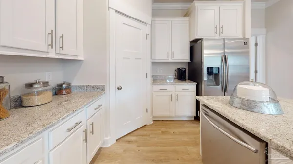 a kitchen with granite countertop a sink stove and refrigerator