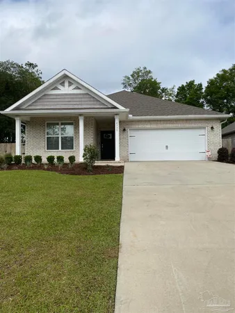 a front view of a house with a yard and potted plants