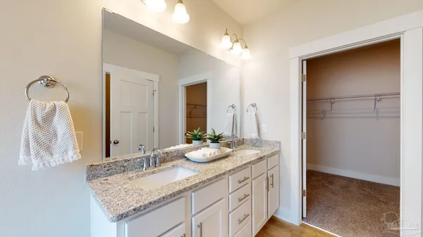 a bathroom with a granite countertop sink and a mirror