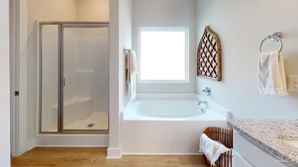 a bathroom with a granite countertop bathtub and shower