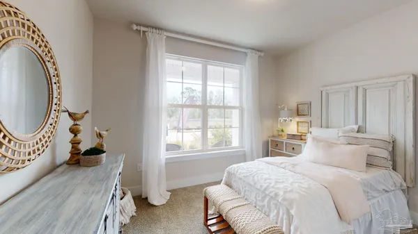 a bedroom with a bed and a mirror on dresser