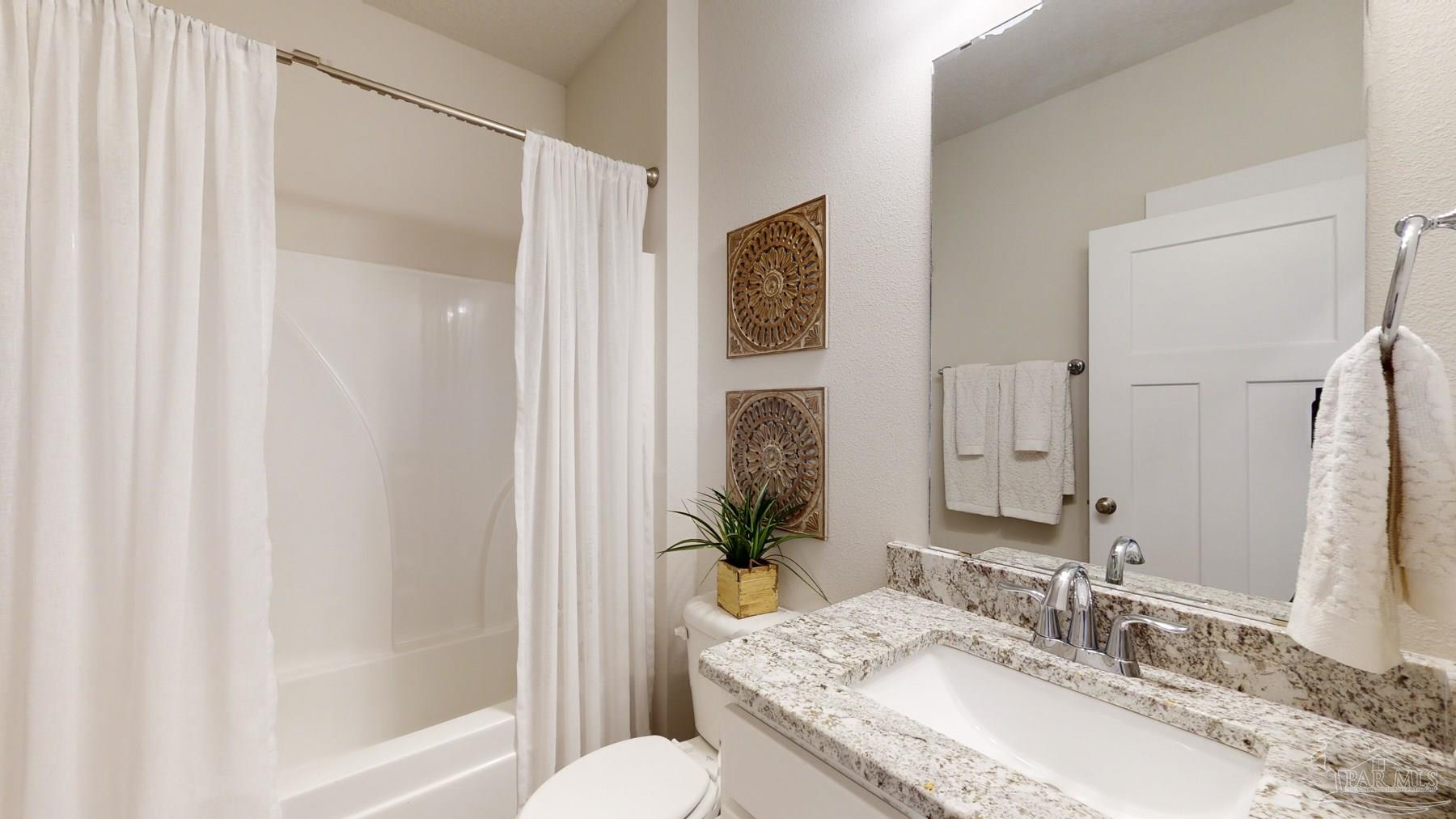 4531 Jude Way Pace, FL 32571 - Photo 34 of 43 a bathroom with a granite countertop tub sink and mirror