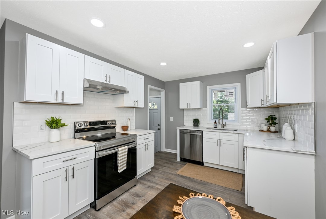263 Forbes Road Bedford, OH 44146 - Photo 9 of 20 Kitchen featuring white cabinetry, sink, stainless steel appliances, and dark hardwood / wood-style floors
