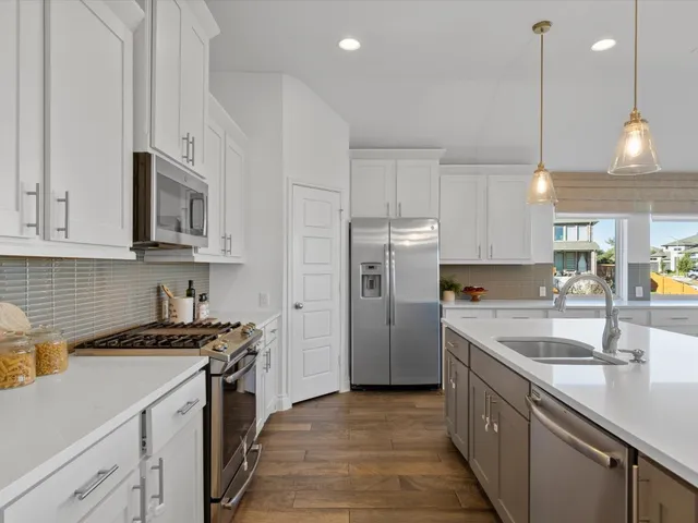 a kitchen with kitchen island a white cabinets and chairs