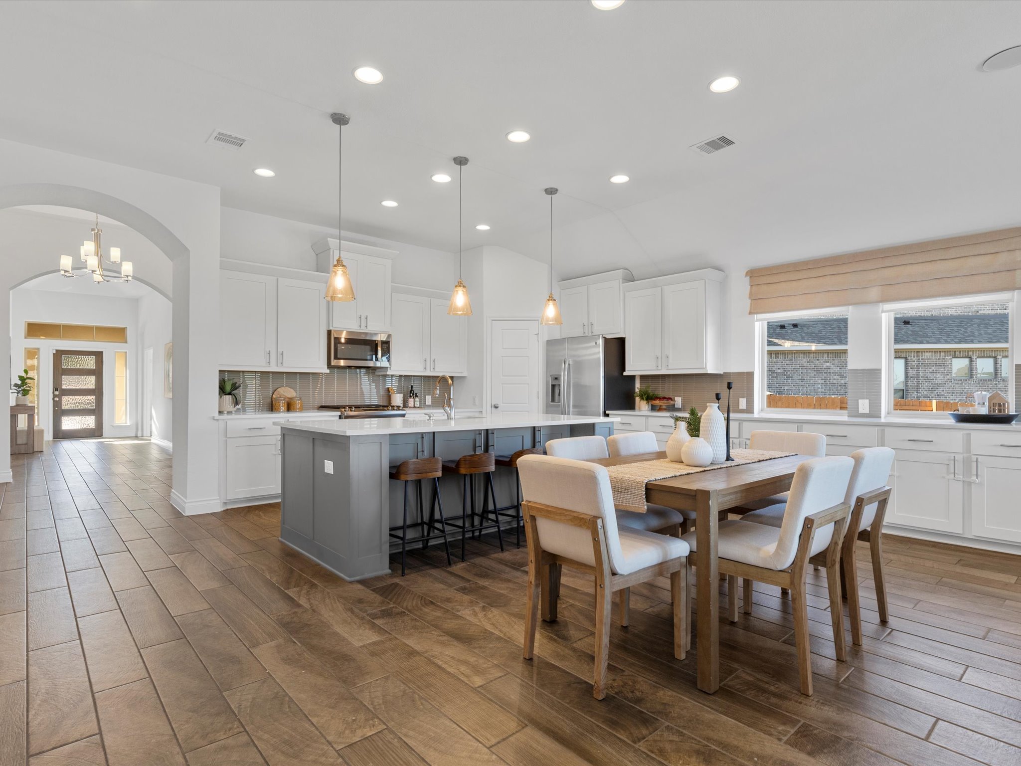 1009 Deer Rim Road Leander, TX 78641 - Photo 5 of 40 a large white dining hall with stainless steel appliances kitchen island granite countertop a table chairs and a refrigerator
