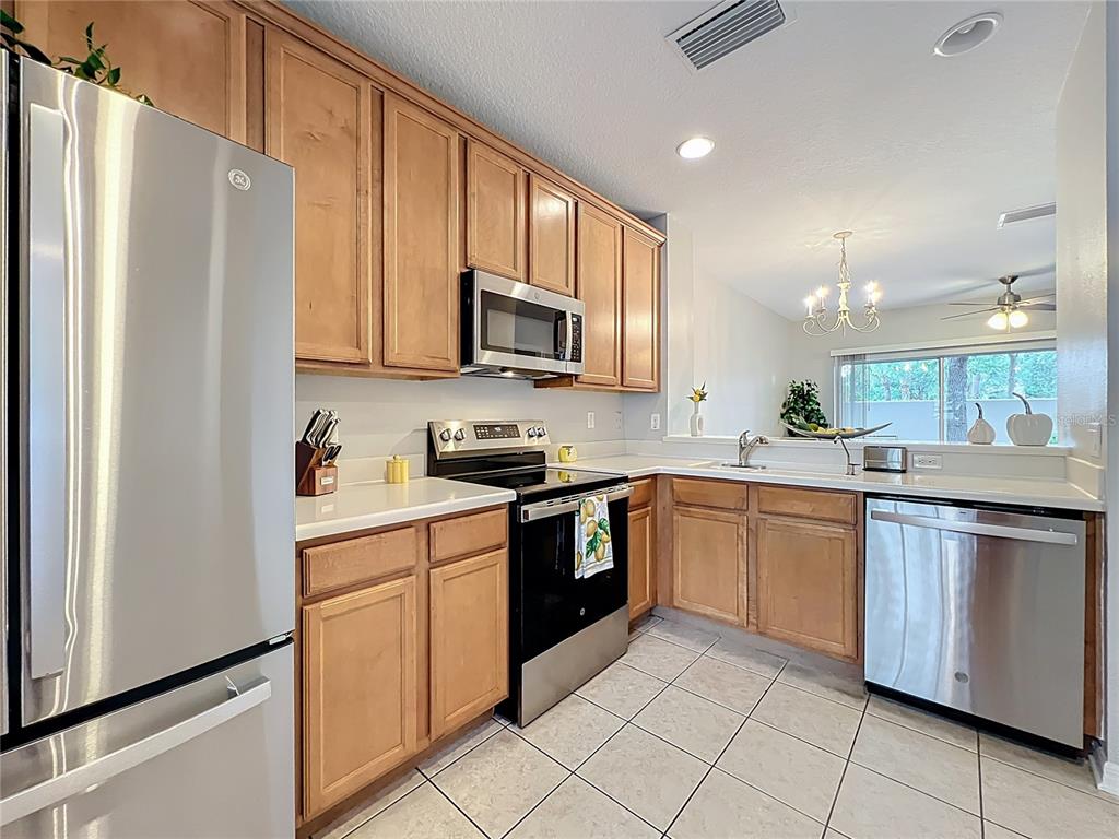 3309 Wilshire Way Road, Unit 3 Orlando, FL 32829 - Photo 9 of 43 a kitchen with stainless steel appliances granite countertop a refrigerator sink and microwave