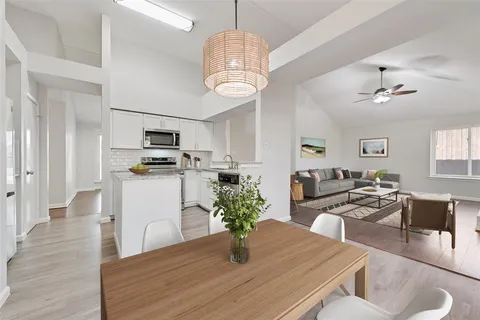 a kitchen with sink refrigerator dining table and chairs