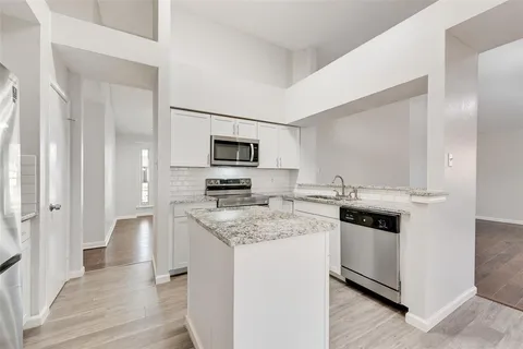 a kitchen with white cabinets and appliances