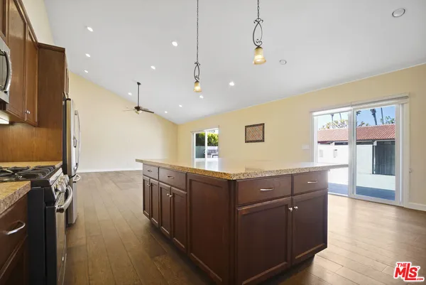 a kitchen with stainless steel appliances granite countertop a sink and wooden cabinets