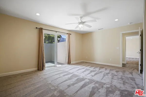 an empty room with fan and entrance