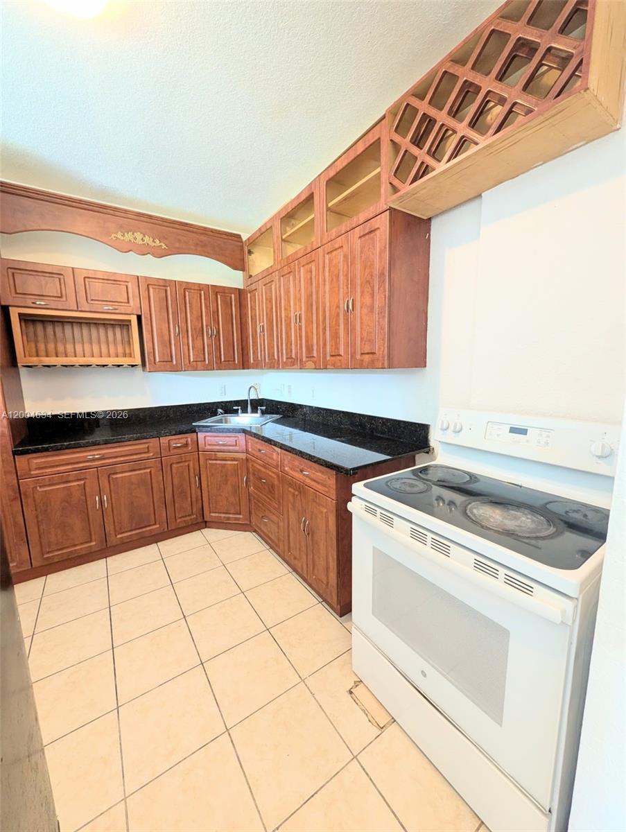 12080 Southwest 268th Street, Unit 27 Homestead, FL 33032 - Photo 6 of 6 a kitchen with a stove a sink and a microwave