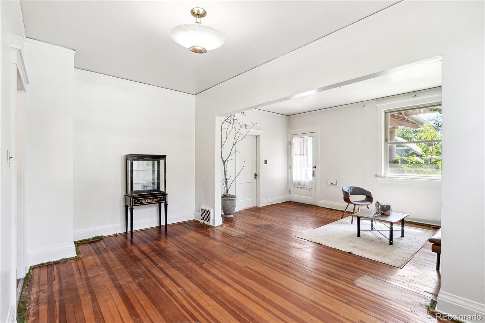 3921 Meade Street Denver, CO 80211 - Photo 11 of 27 a view of a livingroom with wooden floor and a ceiling fan
