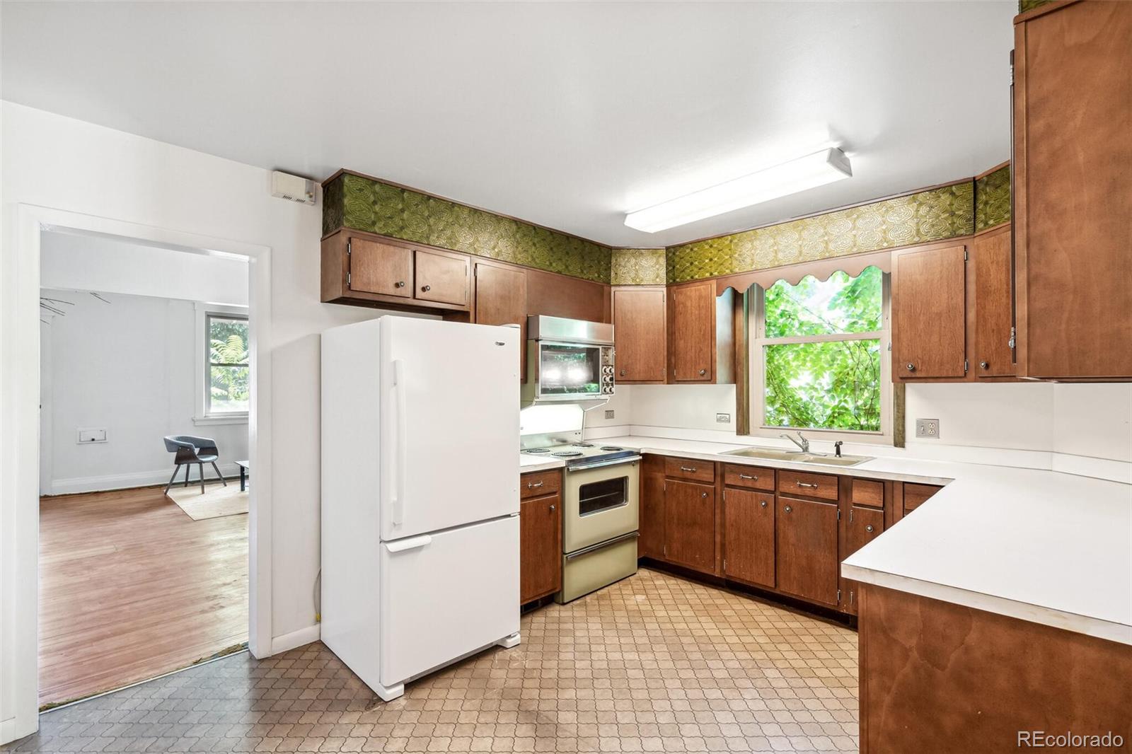 3921 Meade Street Denver, CO 80211 - Photo 13 of 27 a kitchen with a stove a sink and a refrigerator