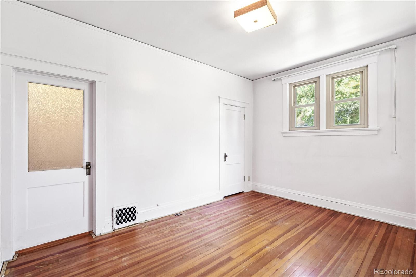 3921 Meade Street Denver, CO 80211 - Photo 17 of 27 an empty room with wooden floor and windows