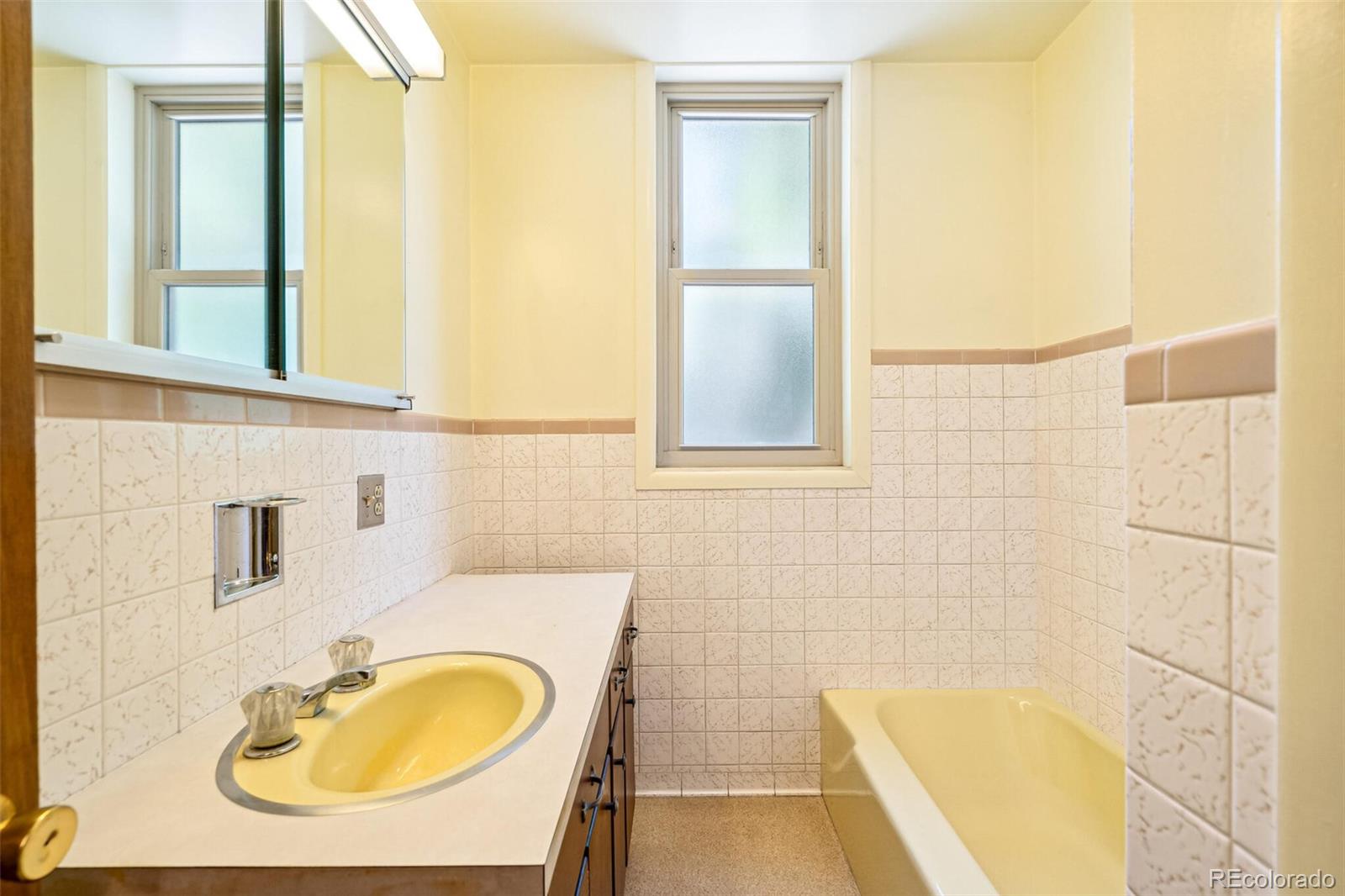 3921 Meade Street Denver, CO 80211 - Photo 18 of 27 a bathroom with a sink mirror and a bathtub