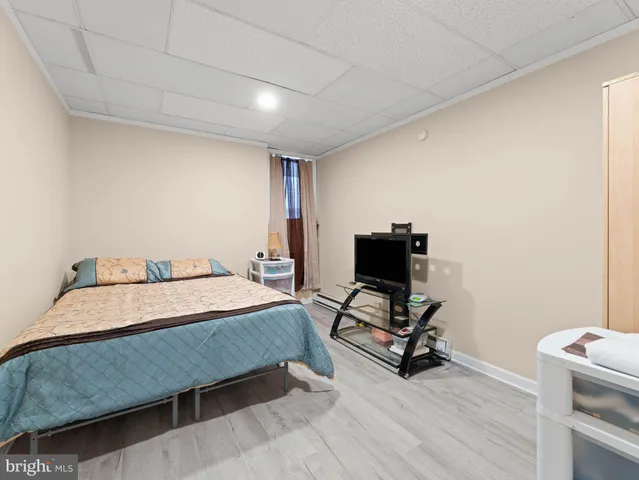 a bedroom with a bed dresser and a flat tv screen