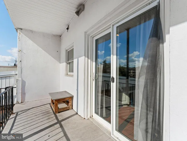 a view of a balcony with wooden floor and a rug