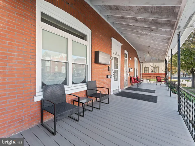 a balcony with chairs and wooden floor