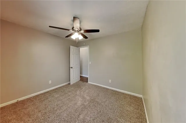 a view of an empty room with a chandelier fan