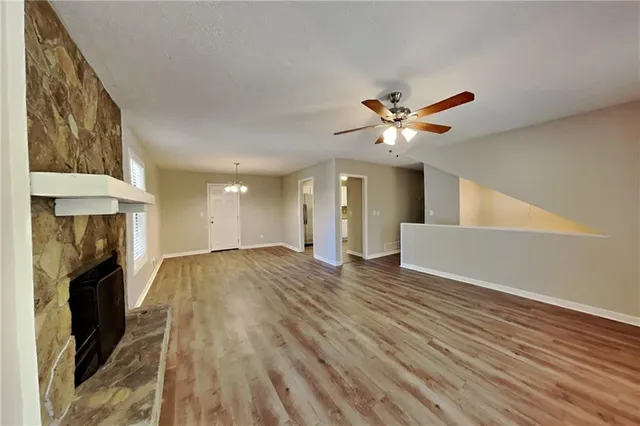 a view of a livingroom with a fireplace a chandelier and wooden floor
