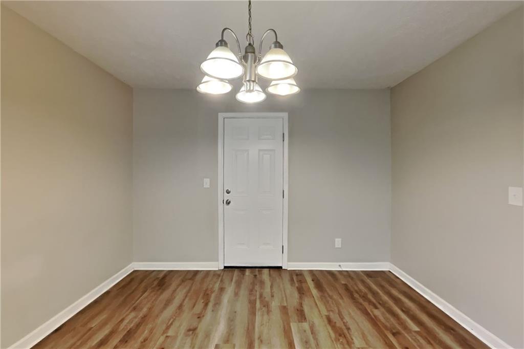 6015 Sumit Court Northwest Kennesaw, GA 30152 - Photo 10 of 24 a view of an empty room with wooden floor and a window