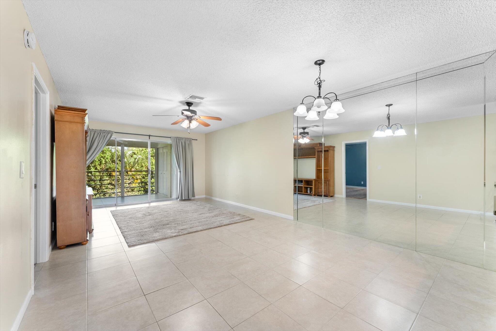5321 Poppy Place, Unit 203 Delray Beach, FL 33484 - Photo 13 of 31 an empty room with a windows and chandelier