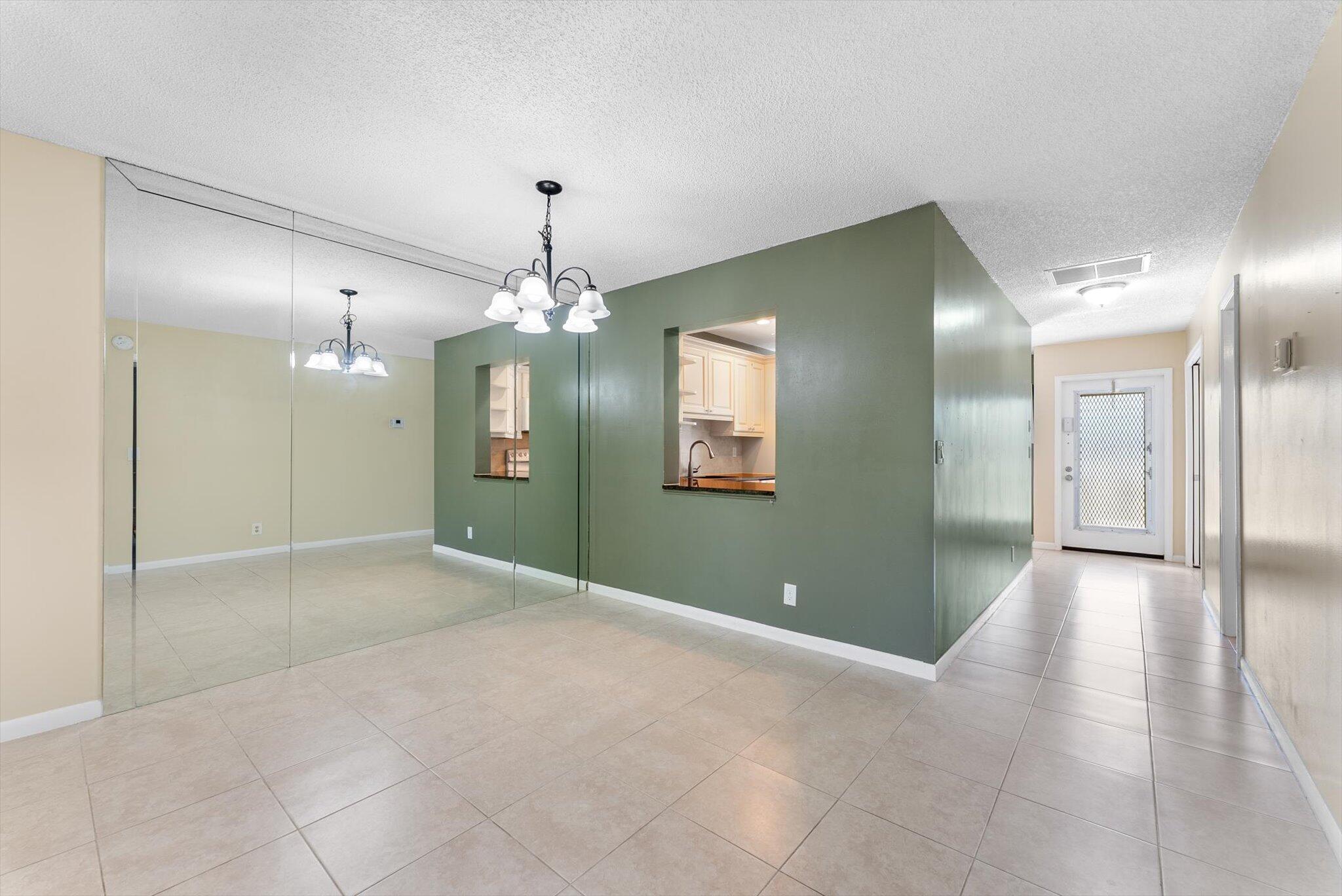 5321 Poppy Place, Unit 203 Delray Beach, FL 33484 - Photo 16 of 31 a view of a hallway with chandelier and glass door