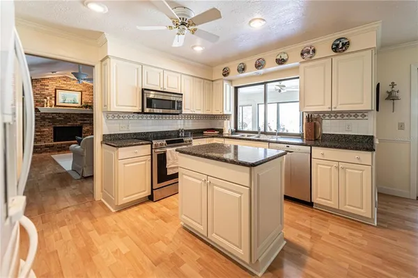 a kitchen with granite countertop a sink stove and cabinets