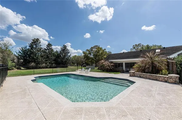 a view of a swimming pool and lounge chairs