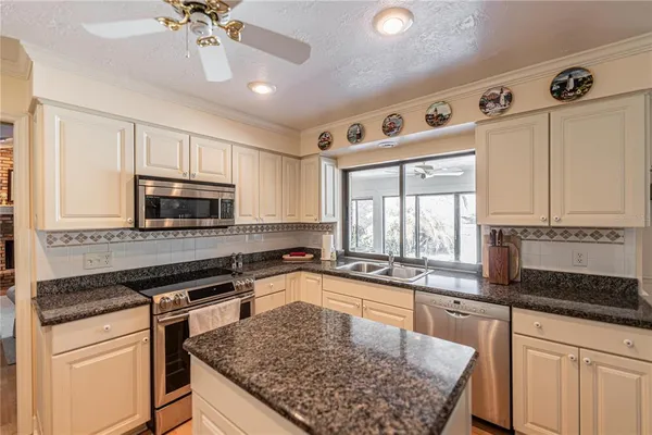 a kitchen with stainless steel appliances granite countertop a sink stove and microwave