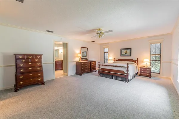 a spacious bedroom with a bed and a chandelier