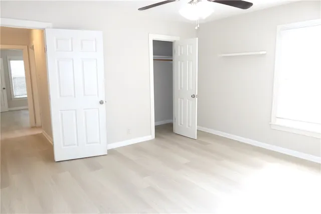 an empty room with windows and closet