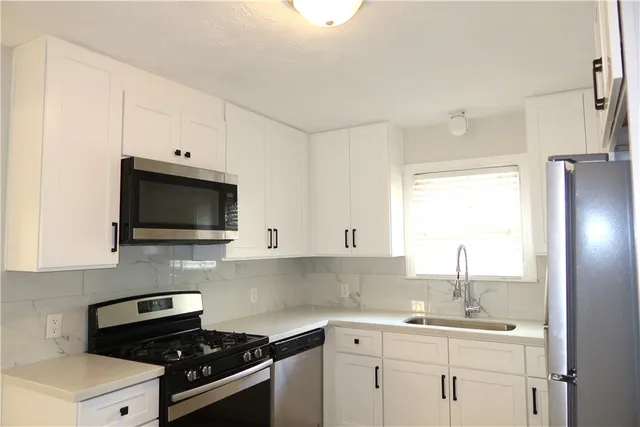 a kitchen with a sink stove and microwave