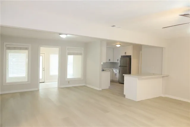 a view of a kitchen with refrigerator and windows