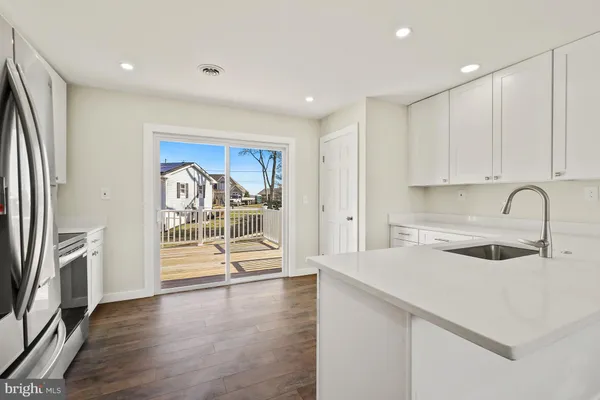 a kitchen with a sink cabinets and wooden floor