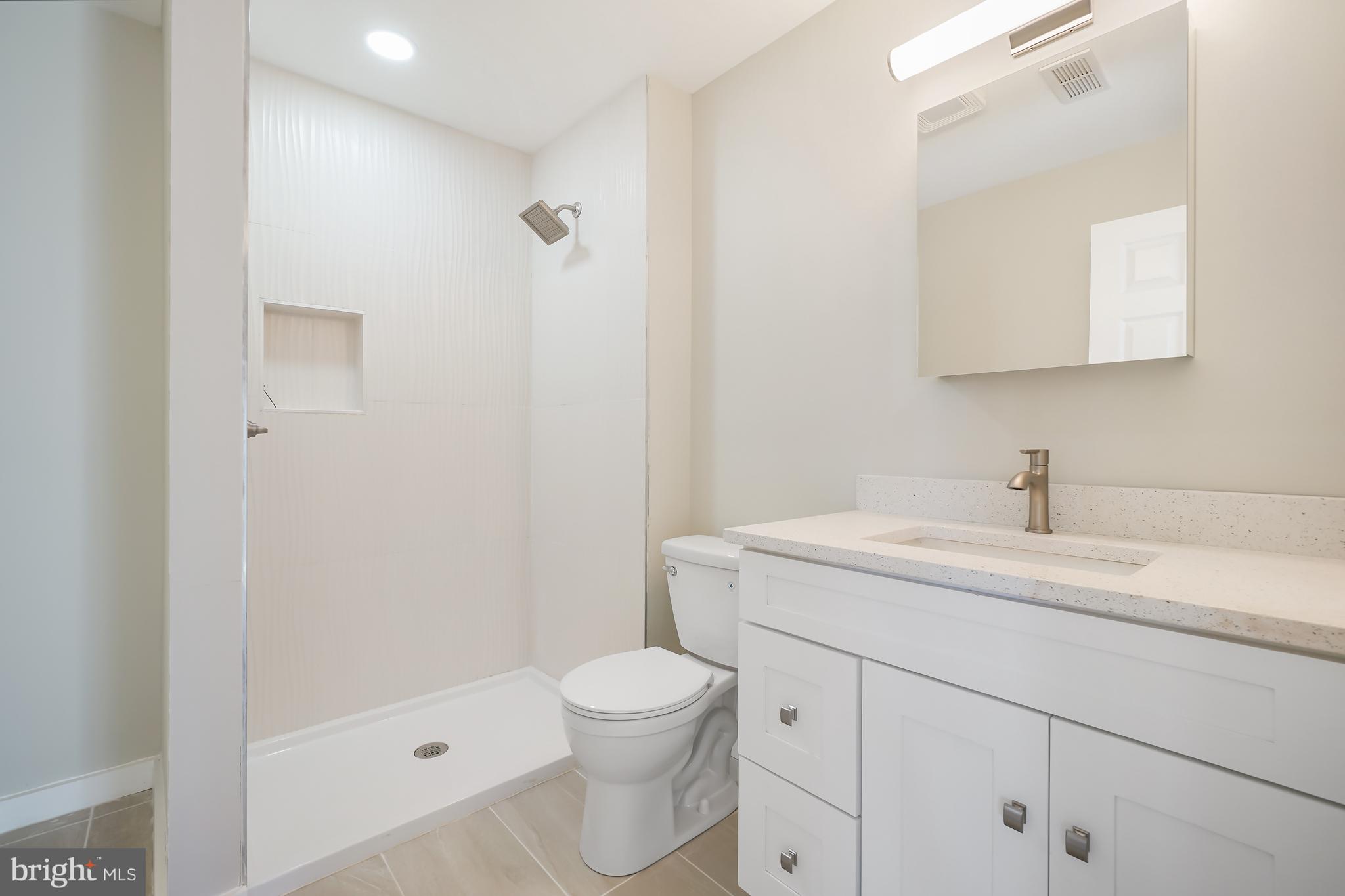 1546 Ridgely Drive Edgewater, MD 21037 - Photo 26 of 55 a bathroom with a granite countertop sink a toilet and a mirror