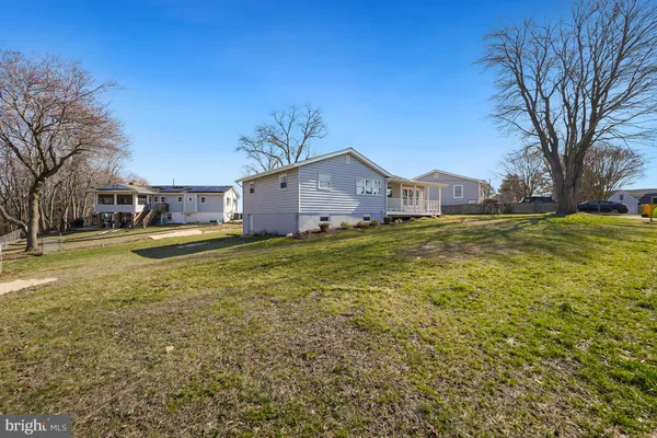 a view of a house with a big yard and large trees