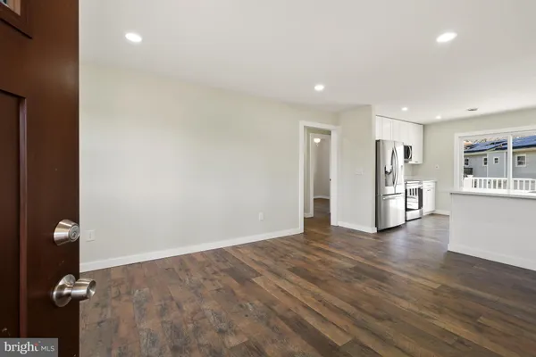 a view of a kitchen with a refrigerator and wooden floor