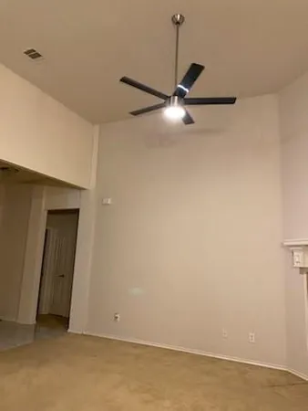 a view of an empty room with a ceiling fan