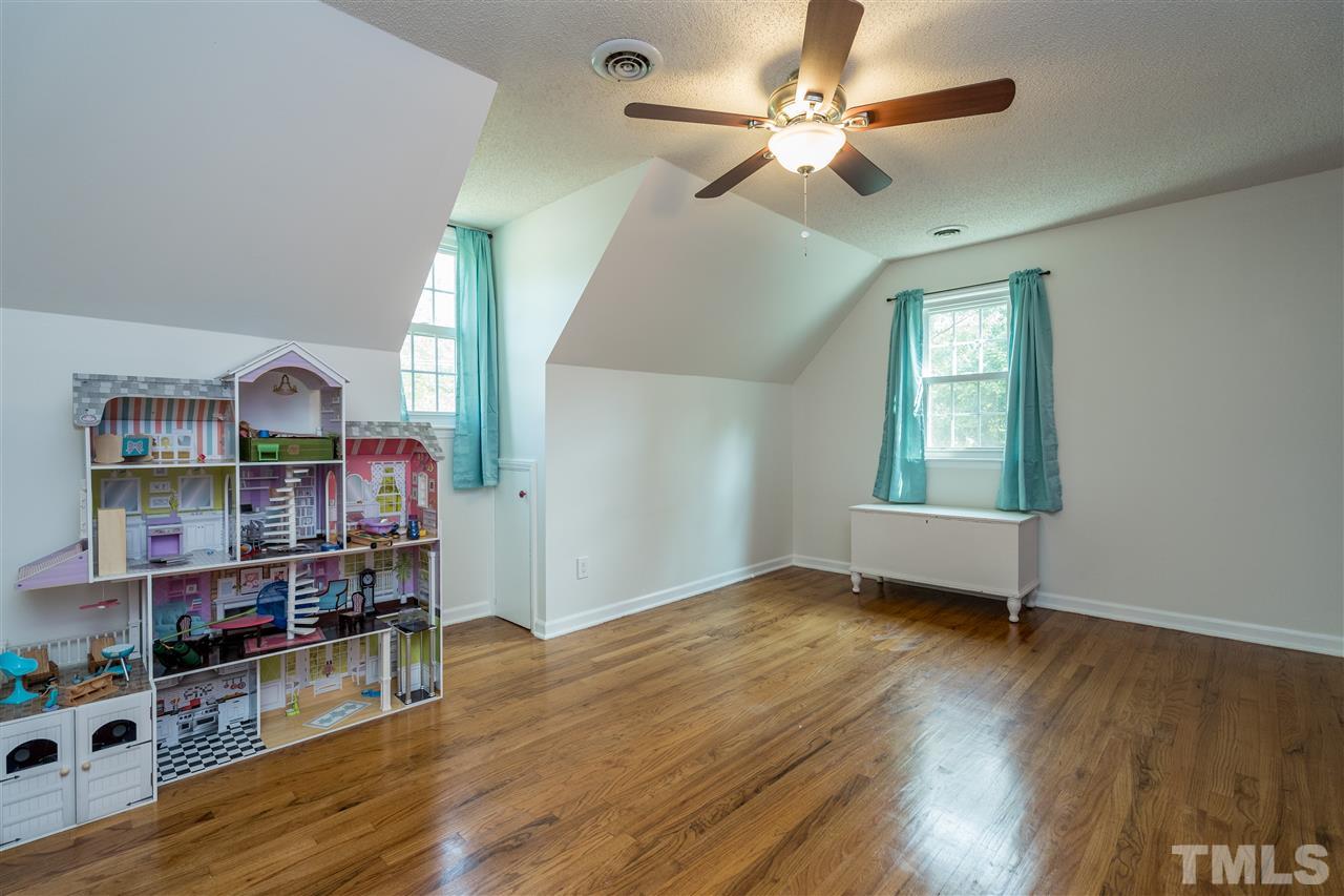 800 Hardimont Road Raleigh, NC 27609 - Photo 13 of 26 an empty room with wooden floor and chandelier fan