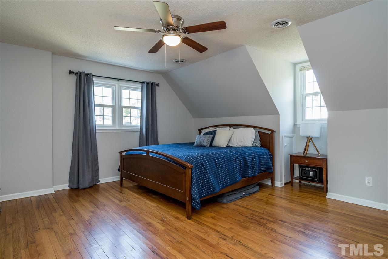 800 Hardimont Road Raleigh, NC 27609 - Photo 17 of 26 a bedroom with a bed chandelier and a window