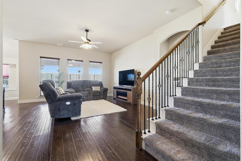 4609 Jasmine Trail Midlothian, TX 76065 - Photo 14 of 34 Living area with a fireplace, dark wood-style flooring, a ceiling fan, and stairway