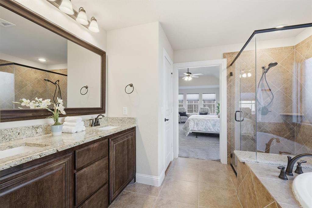 4609 Jasmine Trail Midlothian, TX 76065 - Photo 24 of 34 Ensuite bathroom with double vanity, a bath, a stall shower, light tile patterned floors, and a ceiling fan