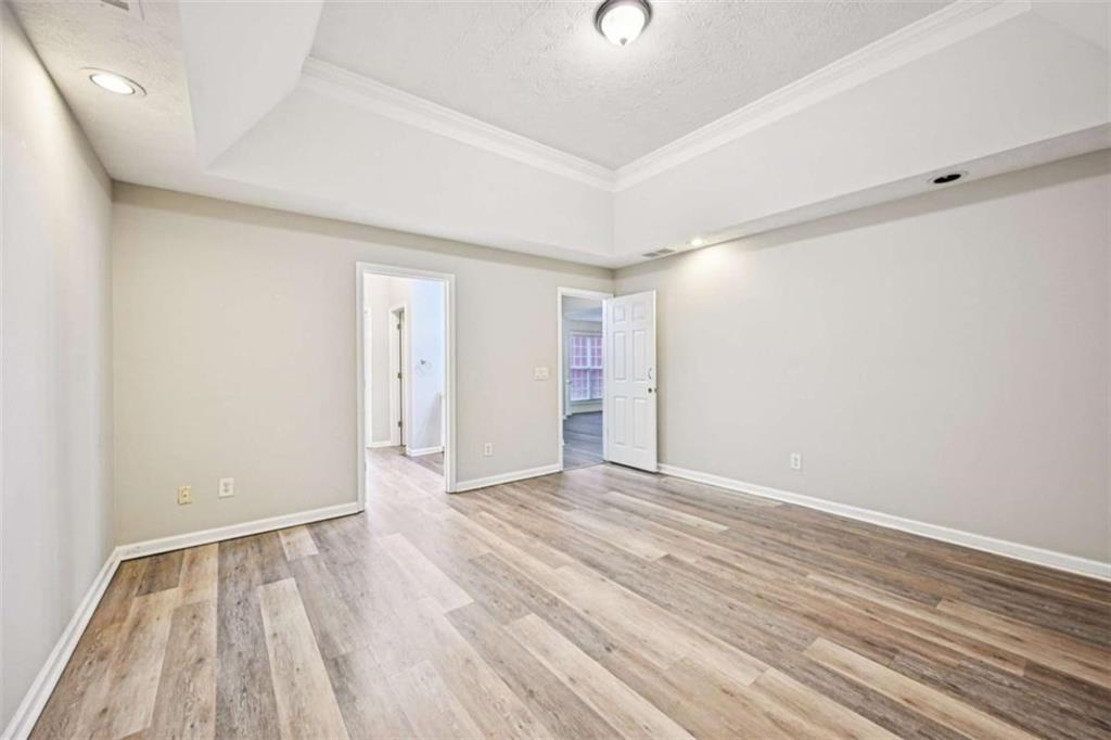25 Castlehill Court Covington, GA 30016 - Photo 12 of 32 an empty room with wooden floor and windows