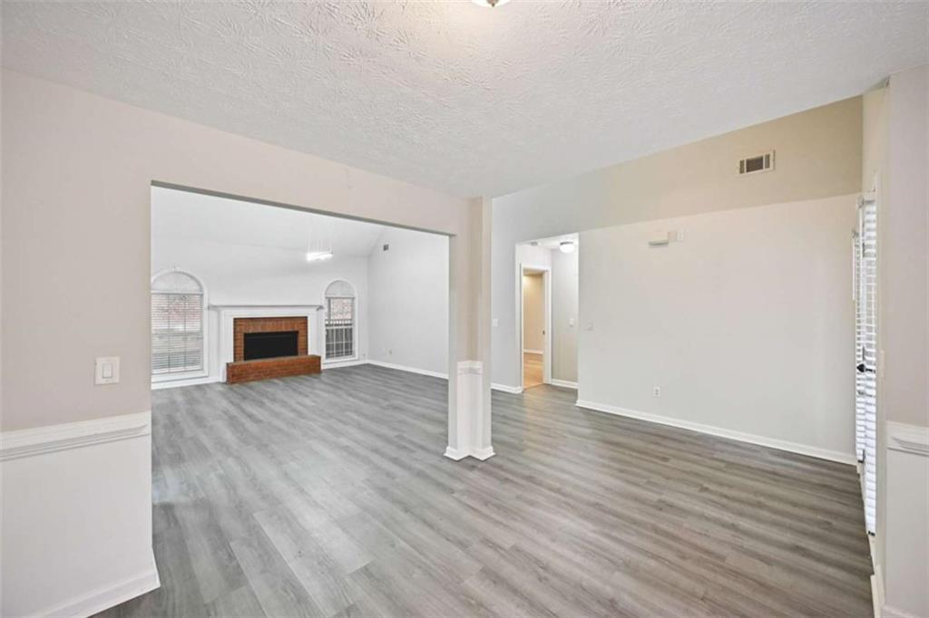 25 Castlehill Court Covington, GA 30016 - Photo 6 of 32 a view of empty room with wooden floor and fireplace
