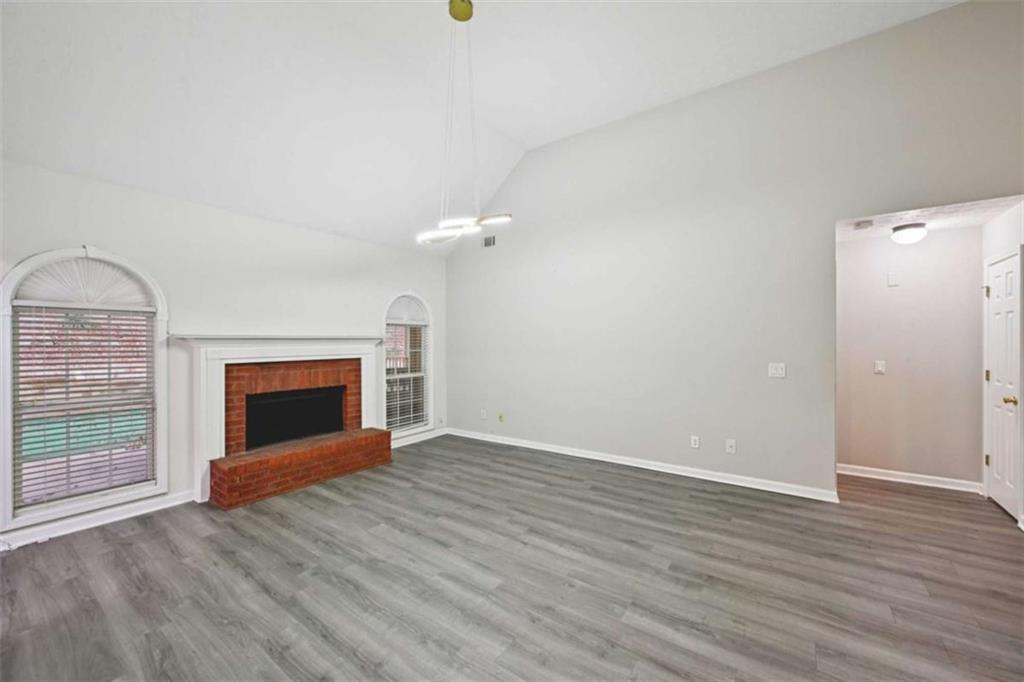 25 Castlehill Court Covington, GA 30016 - Photo 7 of 32 an empty room with wooden floor fireplace and windows