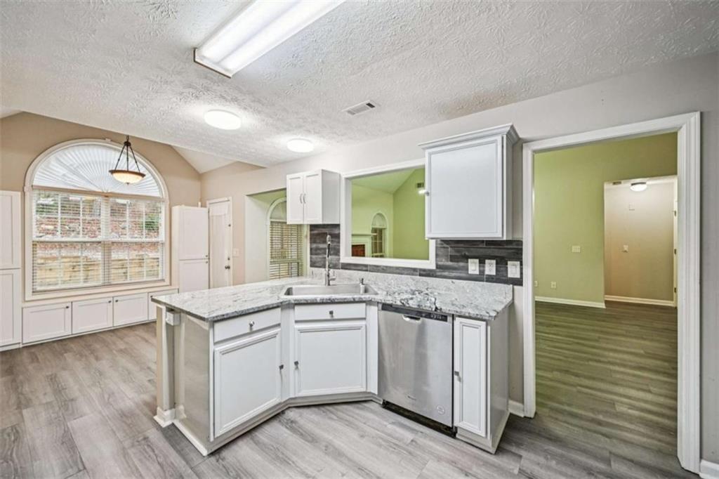 25 Castlehill Court Covington, GA 30016 - Photo 10 of 32 a view of a kitchen counter space with wooden floor and electronic appliances
