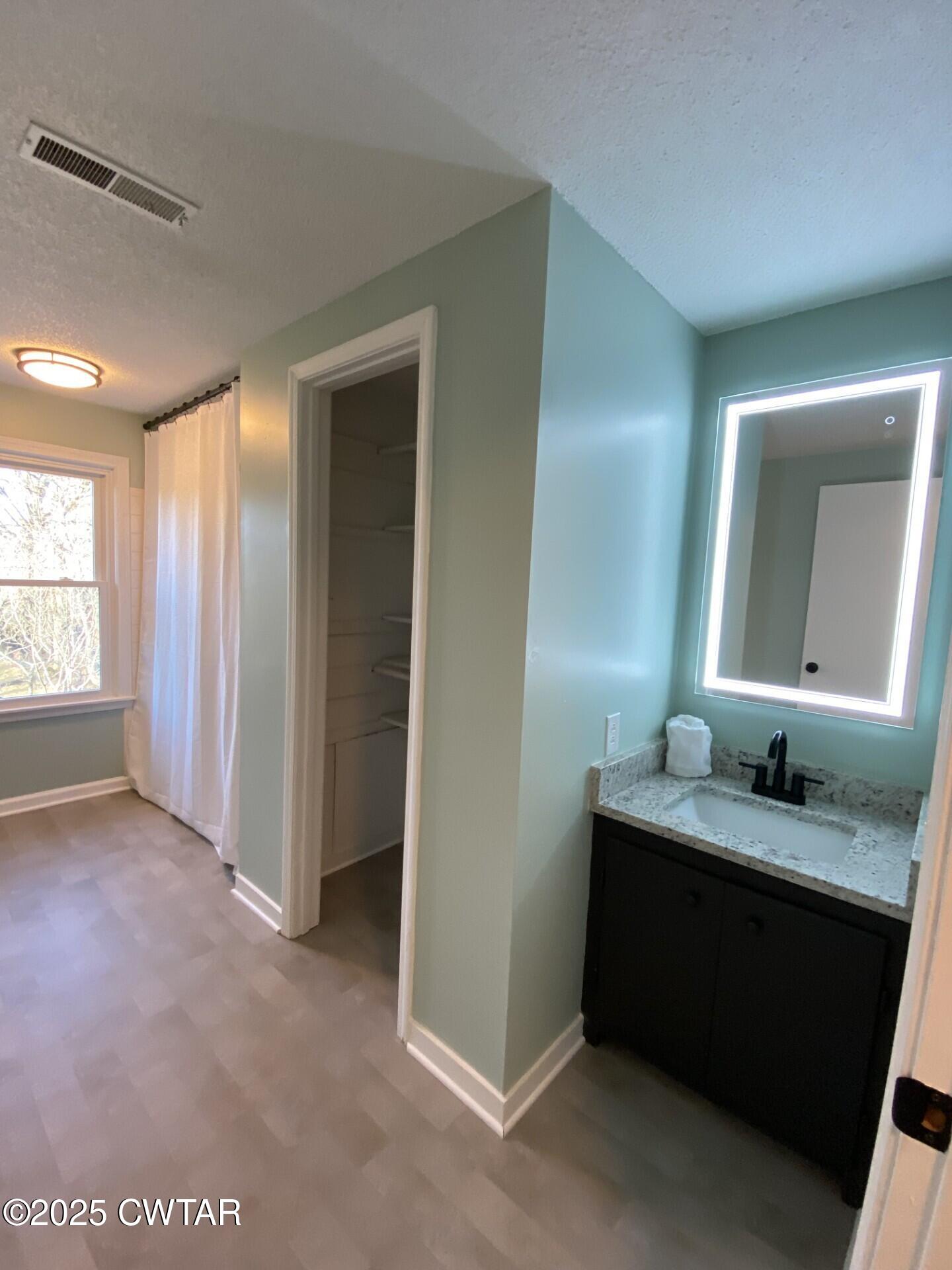 208 4th Street Henderson, TN 38340 - Photo 34 of 62 a bathroom with a granite countertop sink and a mirror