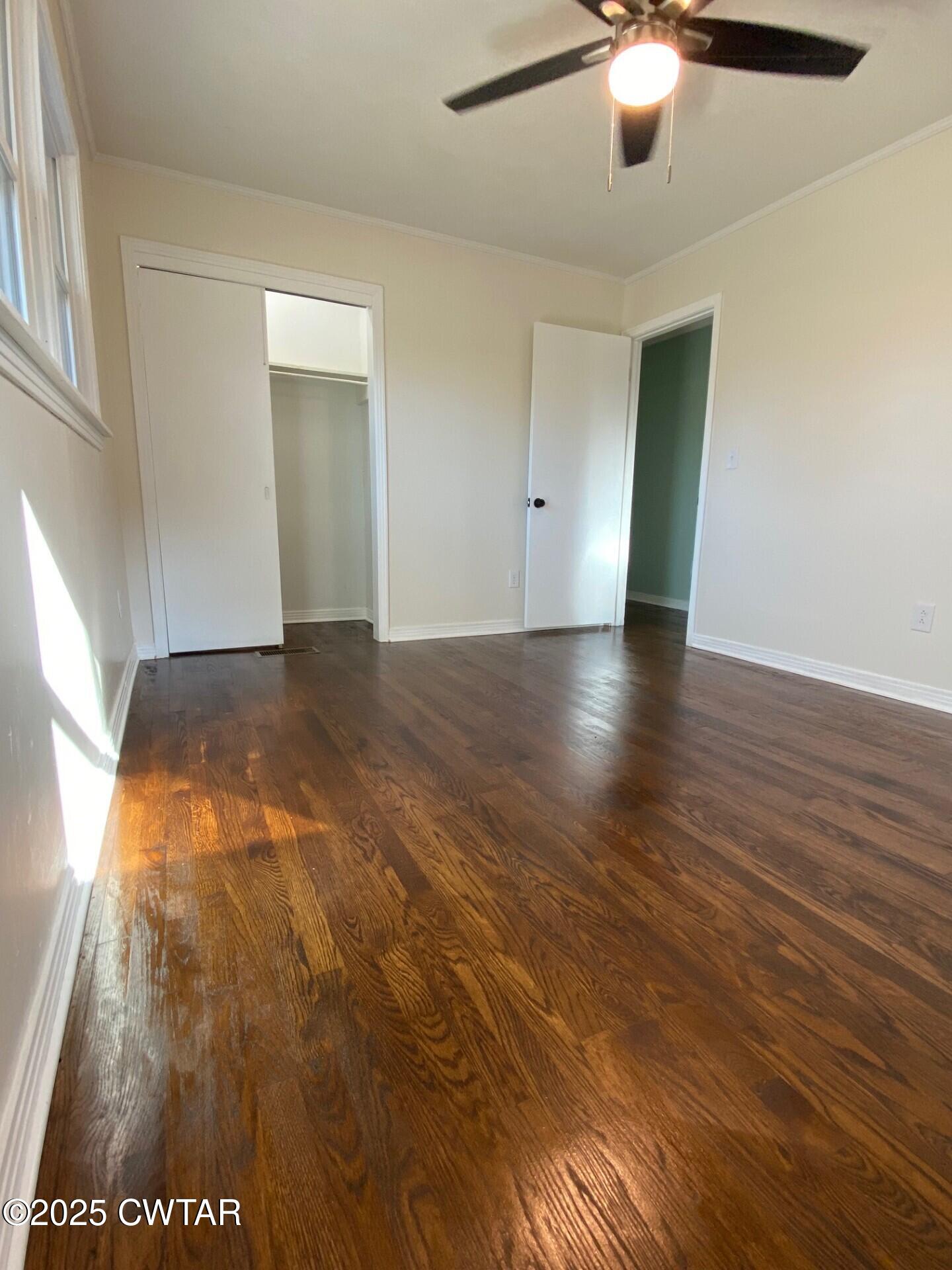 208 4th Street Henderson, TN 38340 - Photo 46 of 62 an empty room with wooden floor fan and windows